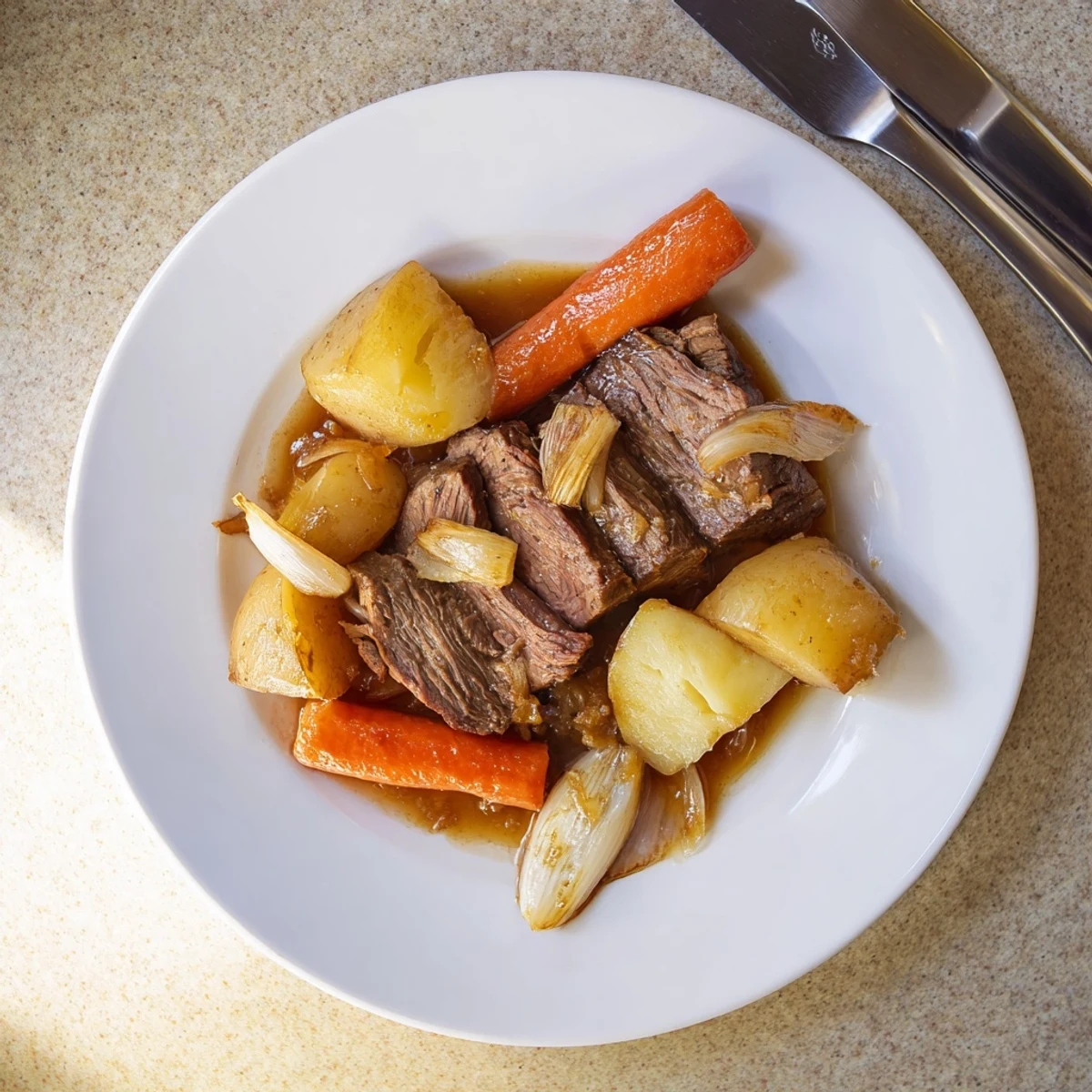 Family-style Beef Pot Roast served steaming hot with savory gravy in a rustic Dutch oven.