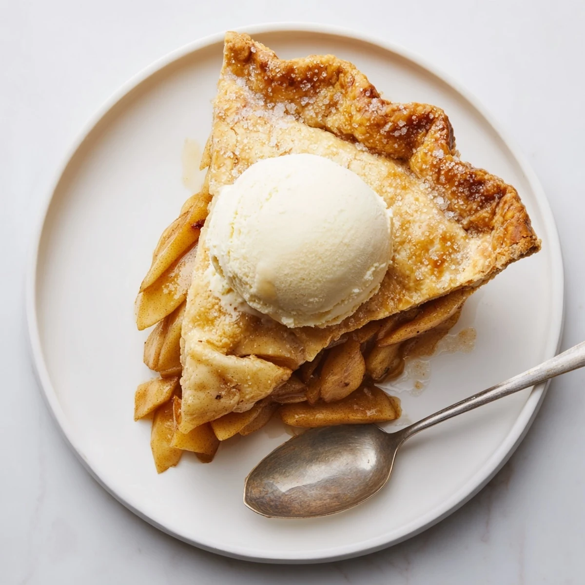 Classic apple pie served warm from the oven with a melting scoop of vanilla ice cream.