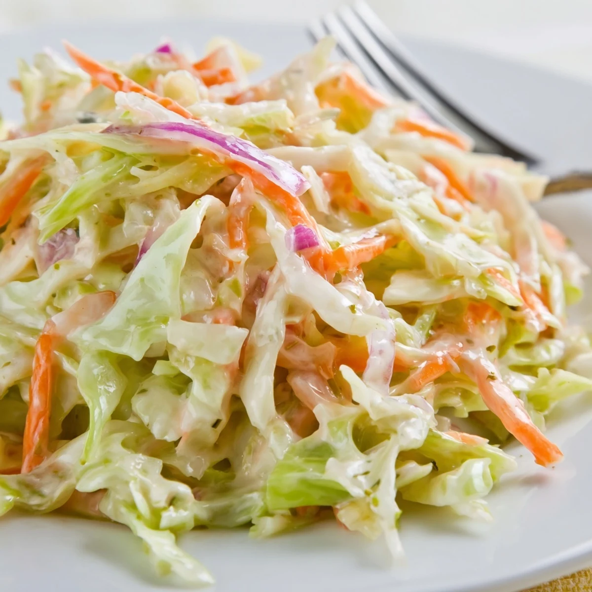 Classic Coleslaw in a rustic serving dish, paired with barbecue pulled pork sliders on soft buns for a picnic.