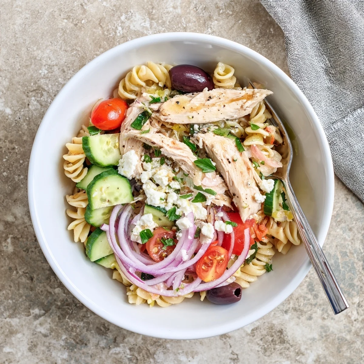 Savory Greek Chicken Pasta Bowl garnished with fresh parsley, offering a refreshing Mediterranean-inspired main dish perfect for weeknight dinners.