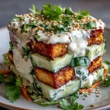 Fresh, crunchy cucumbers and carrots are drizzled with a creamy Asian dressing, topped with golden crispy tofu for a protein-packed lunch.  