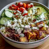 Colorful Customizable Grain Bowl with avocado slices, fresh cucumbers, and crunchy pumpkin seeds atop a bed of fluffy brown rice.