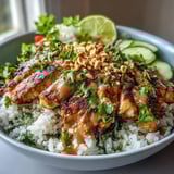 Fluffy coconut rice topped with grilled chicken, crunchy vegetables, and rich peanut sauce for a balanced meal.  
