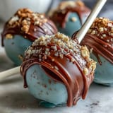 Colorful cake pops in school colors, dipped in candy coating and adorned with gold sprinkles for a graduation party centerpiece.  