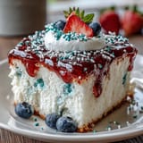 Festive Red White Blue Poke Cake featuring creamy whipped topping and colorful gelatin pockets, perfect for Memorial Day celebrations and summer gatherings.
