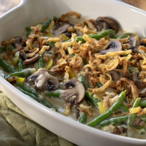 Golden brown crispy fried onions top this classic Green Bean Casserole, bubbling in a baking dish.