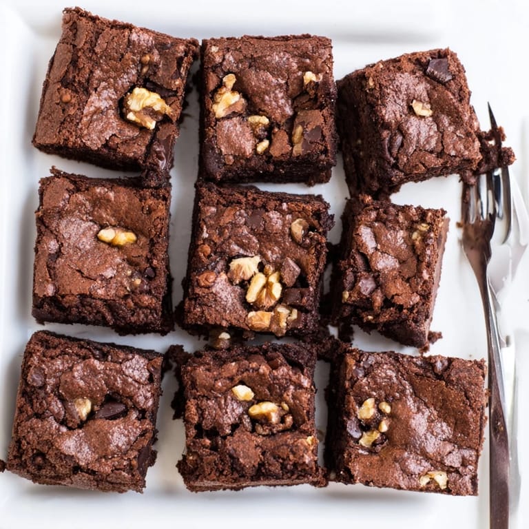 Rich fudgy Brownies stacked high served warm with a scoop of vanilla ice cream.